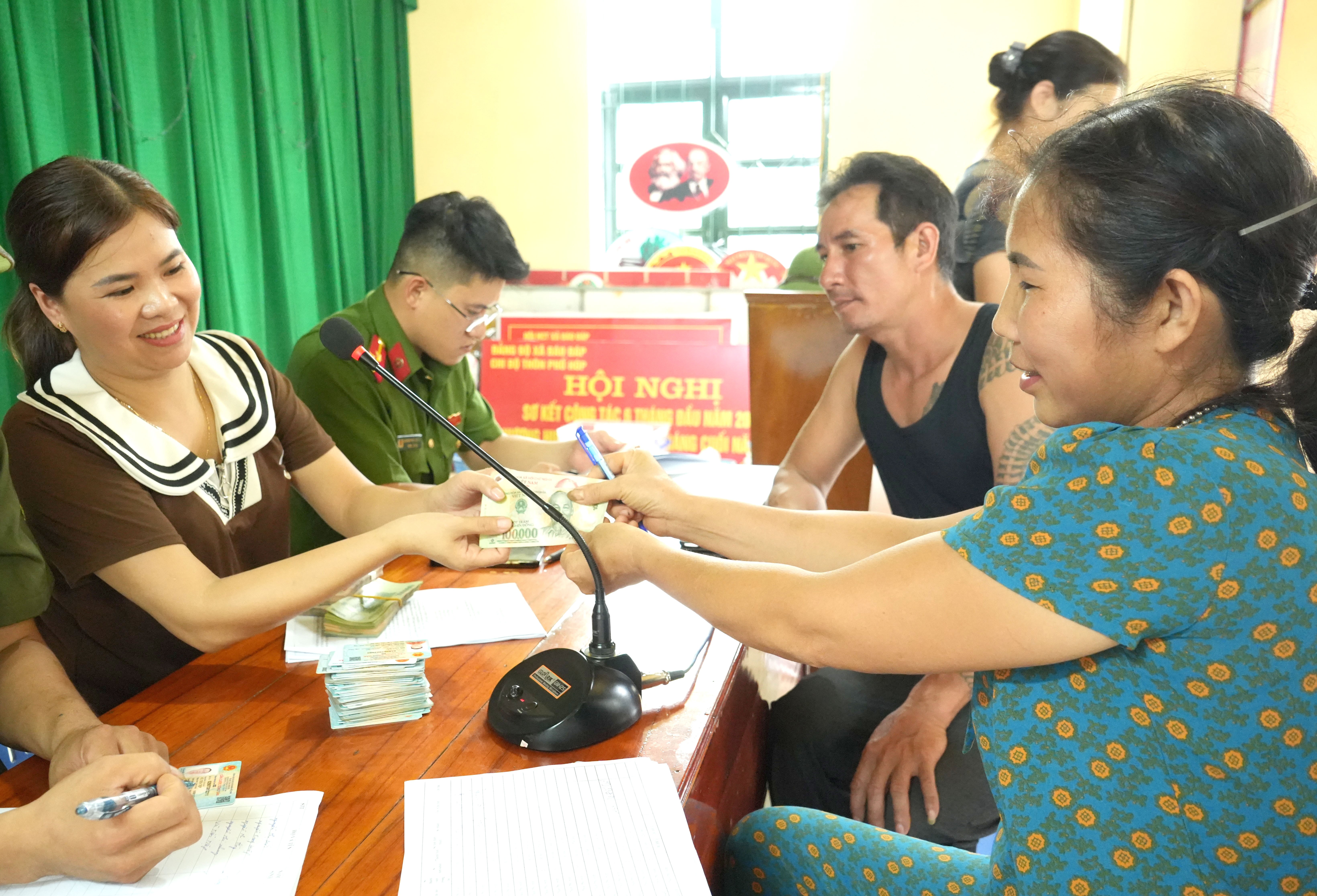 Người dân phấn khởi đến nhà văn hóa thôn để nhận quà. anh5.jpg