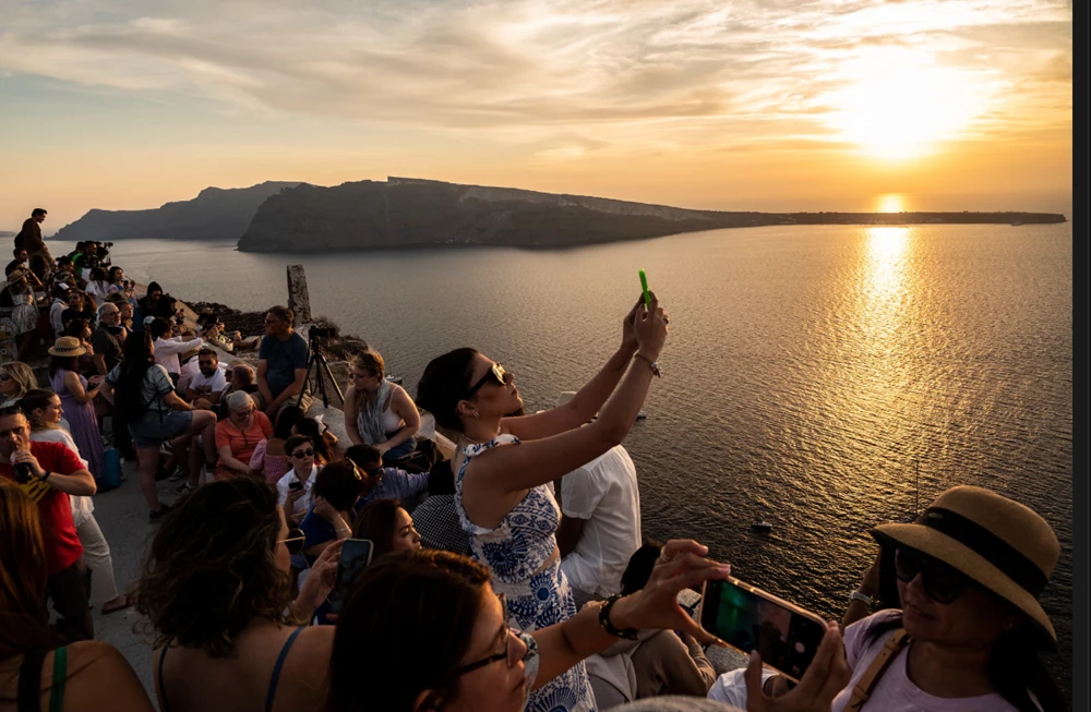 Du khách chụp ảnh và selfie lúc hoàng hôn trên đảo Santorini, Hy Lạp. Ảnh: Getty Images