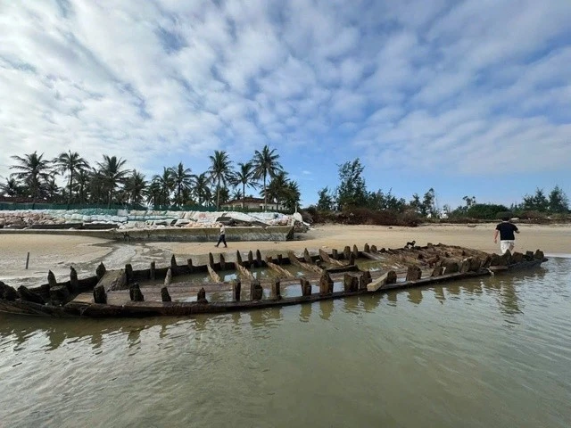Du khách và người dân đứng quanh tàu, ngắm nhìn hình dáng và các chi tiết gỗ cổ kính.