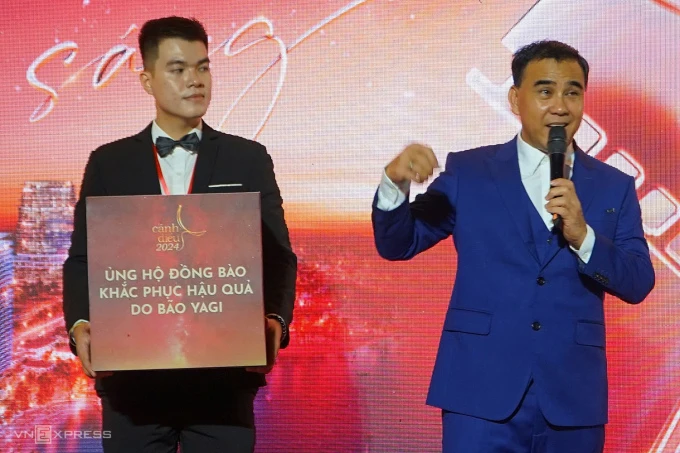 Quyền Linh đại diện đoàn phim "Hai Muối" ủng hộ người dân khắc phục hậu quả sau bão. Ảnh: Bùi Toàn