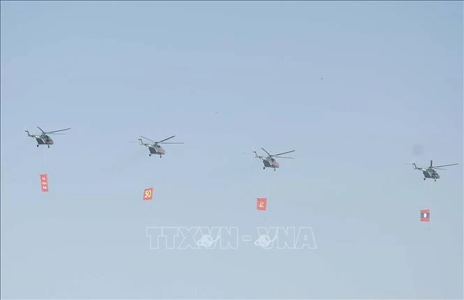 Biên đội máy bay trực thăng mang cờ bay trên bầu trời khu vực tổ chức lễ kỷ niệm.