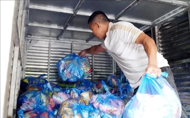 Xếp hàng cứu trợ lên xe tải để chở vào cứu trợ người dân vùng lũ Gia Lai.