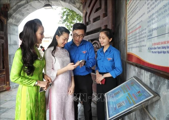 Đoàn viên Thanh niên thành phố Bắc Giang hướng dẫn du khách quét mã QR tìm hiểu về di tích lịch sử Quốc gia đặc biệt Địa điểm Chiến thắng Xương Giang.