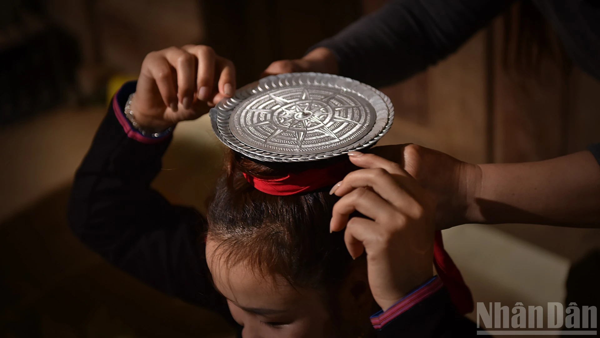 Chiếc đĩa bạc được đặt trên đỉnh đầu người đội.