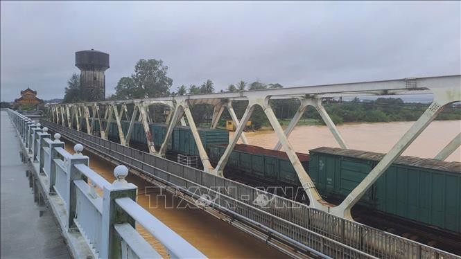 Đoàn tàu dừng trên cầu đường sắt Bạch Hổ bắc qua sông Hương, thành phố Huế để gia tải chống trôi cầu khi lũ dâng cao.