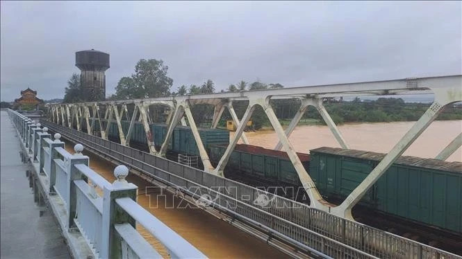 Đoàn tàu dừng trên cầu đường sắt Bạch Hổ bắc qua sông Hương, thành phố Huế để gia tải chống trôi cầu khi lũ dâng cao.