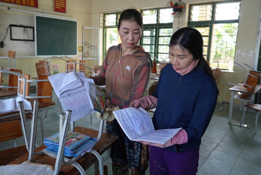 Giáo viên Trường Tiểu học Phạm Hồng Thái (Lam Thành, Nghệ An) kiểm tra lại đồ dùng, sách vở học sinh sau lũ. giao-duc-lu.jpg