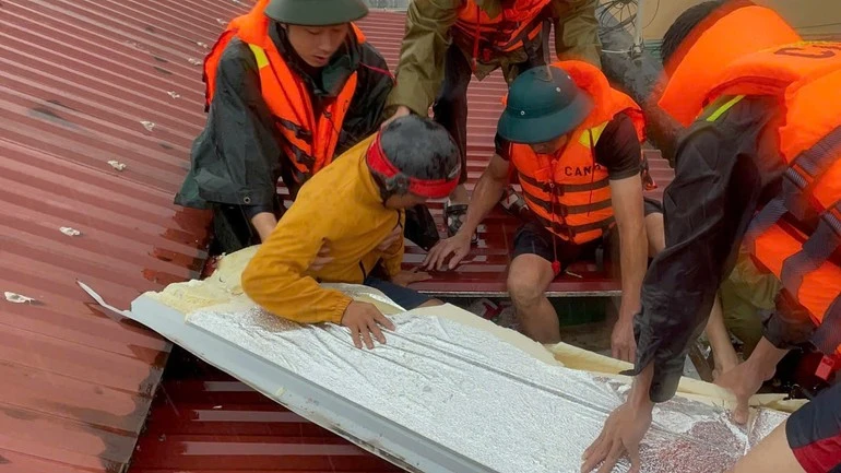 Lực lượng Công an cứu hai người dân xã Trại Cau, tỉnh Thái Nguyên mắc kẹt trong nhà bị ngập nước và đưa ra khu vực an toàn.