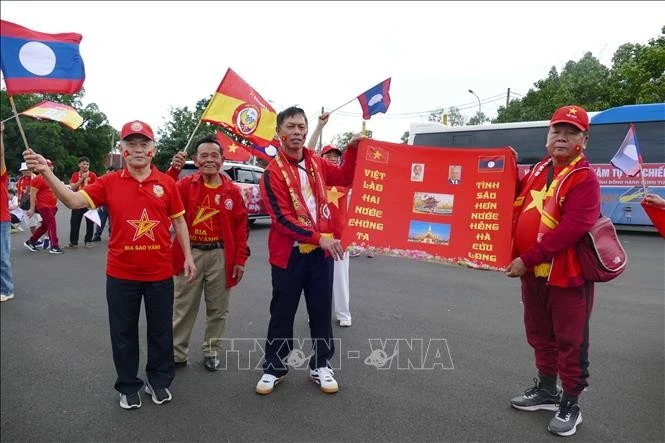 Cổ động viên tuyển Việt Nam mang theo ảnh Bác Hồ cổ vũ cho đội nhà.