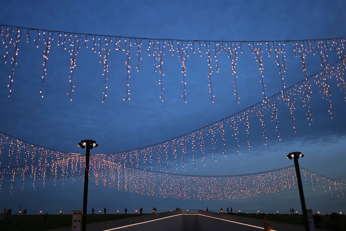 Người dân đi bộ dọc theo bến phà Kabatas được trang trí đèn rực rỡ cho mùa lễ hội tại Istanbul (Thổ Nhĩ Kỳ).