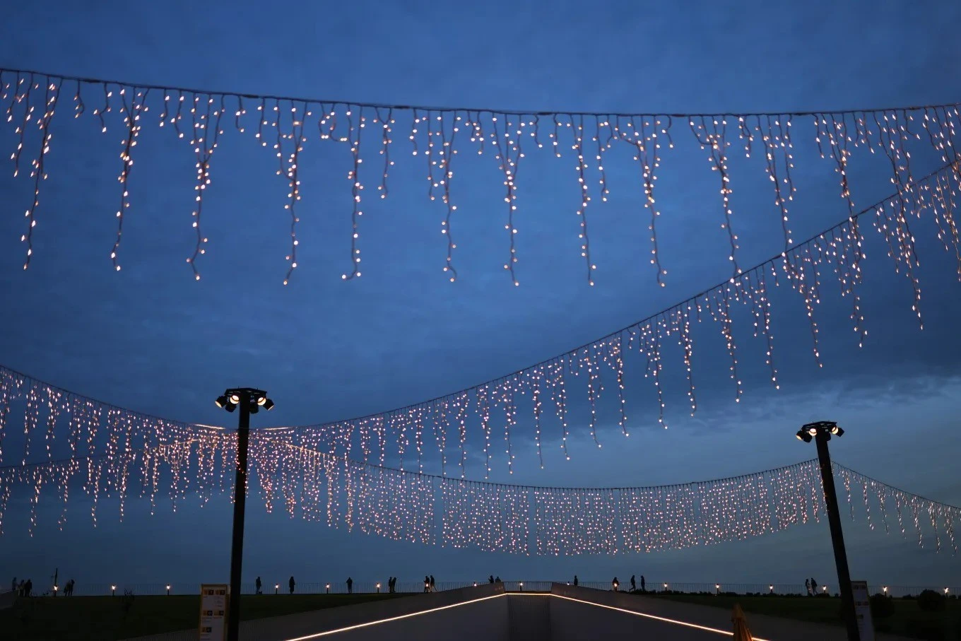 Người dân đi bộ dọc theo bến phà Kabatas được trang trí đèn rực rỡ cho mùa lễ hội tại Istanbul (Thổ Nhĩ Kỳ).