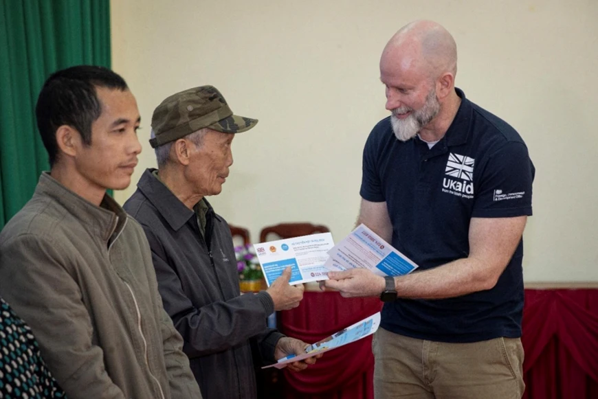 Ông Fergus McBean, Bí thư Thứ nhất phụ trách Khí hậu và thiên nhiên, Đại sứ quán Anh, trao tiền hỗ trợ cho các hộ gia đình bị ảnh hưởng bởi bão lũ vừa qua tại Lạng Sơn. Ảnh: UNICEF