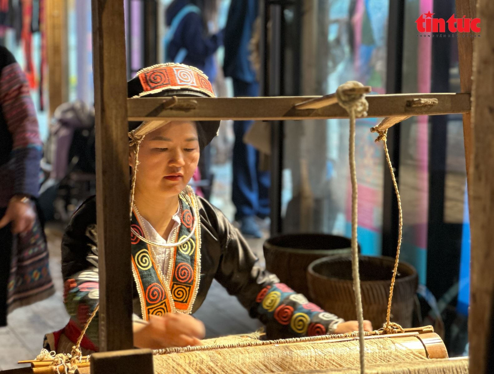 Nghệ nhân dệt vải trên khung cửi ngay tại hội chợ.
