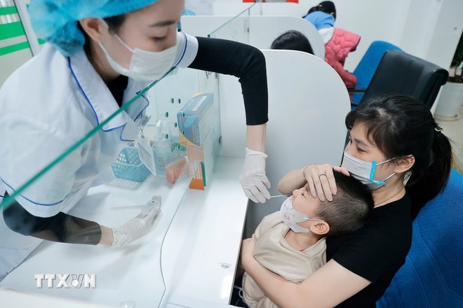 Nhân viên y tế lấy mẫu test cúm cho bệnh nhi.