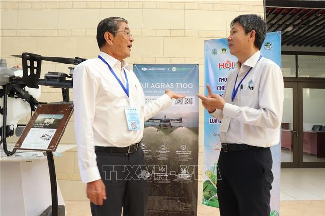 Anh hùng Lao động Hồ Quang Cua (trái) chia sẻ với Phó Giáo sư, Tiến sĩ Lê Văn Vàng, Hiệu trưởng trường Nông nghiệp (Đại học Cần Thơ) về ứng dụng chế phẩm vi sinh vào quy trình canh tác lúa ST25 an toàn.