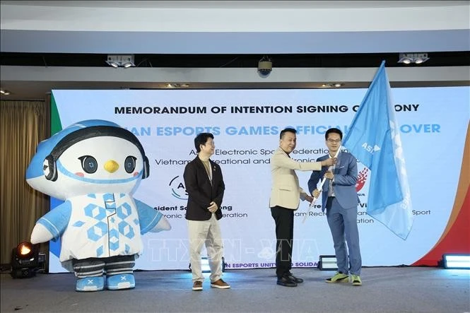 Ông Santi Lothong, Chủ tịch Liên đoàn Thể thao điện tử châu Á (giữa) trao cờ đại hội cho đại diện Việt Nam - quốc gia đăng cai AEG 2026.