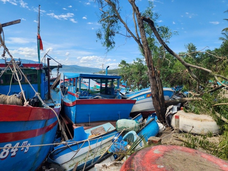 Tàu cá công suất lớn bị sóng đánh vào bờ làm gãy cây xanh, sập nhà tạm của người dân trên bờ.
