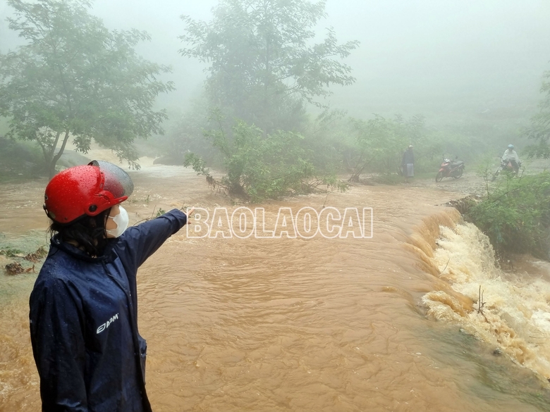Cử người cảnh giới và cắm biển cảnh báo những vị trí ngầm tràn có nguy cơ cao xảy ra ngập úng, lũ ống, lũ quét. Ảnh: Tất Đạt a1-7-452.jpg