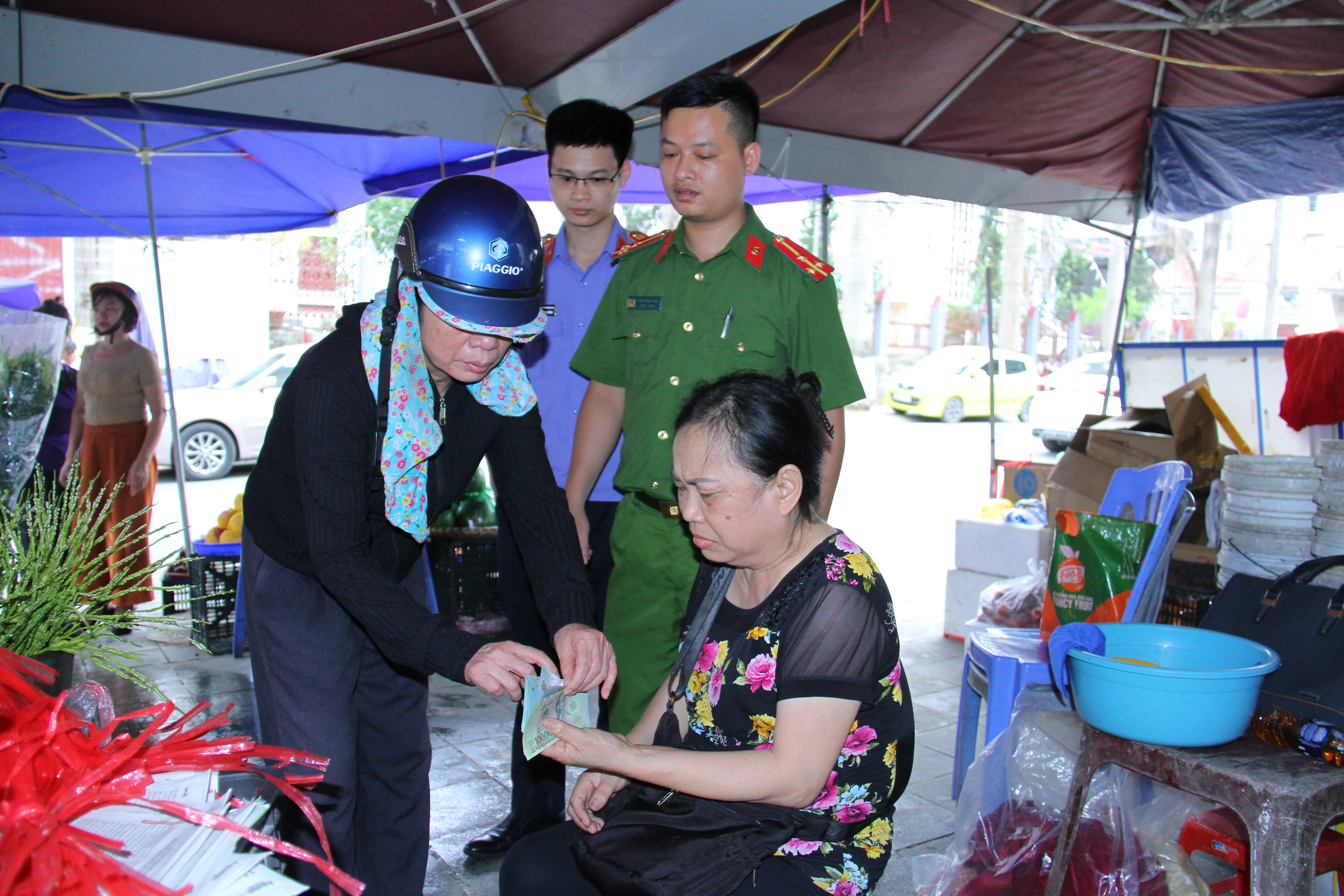 Ảnh 1. Thực nghiệm hiện trường đối tượng Trần Thị Gái áo đen dùng thủ thuật đổi tiền để chiếm đoạt tài sản ở 3 chợ trên địa bàn (3).JPG