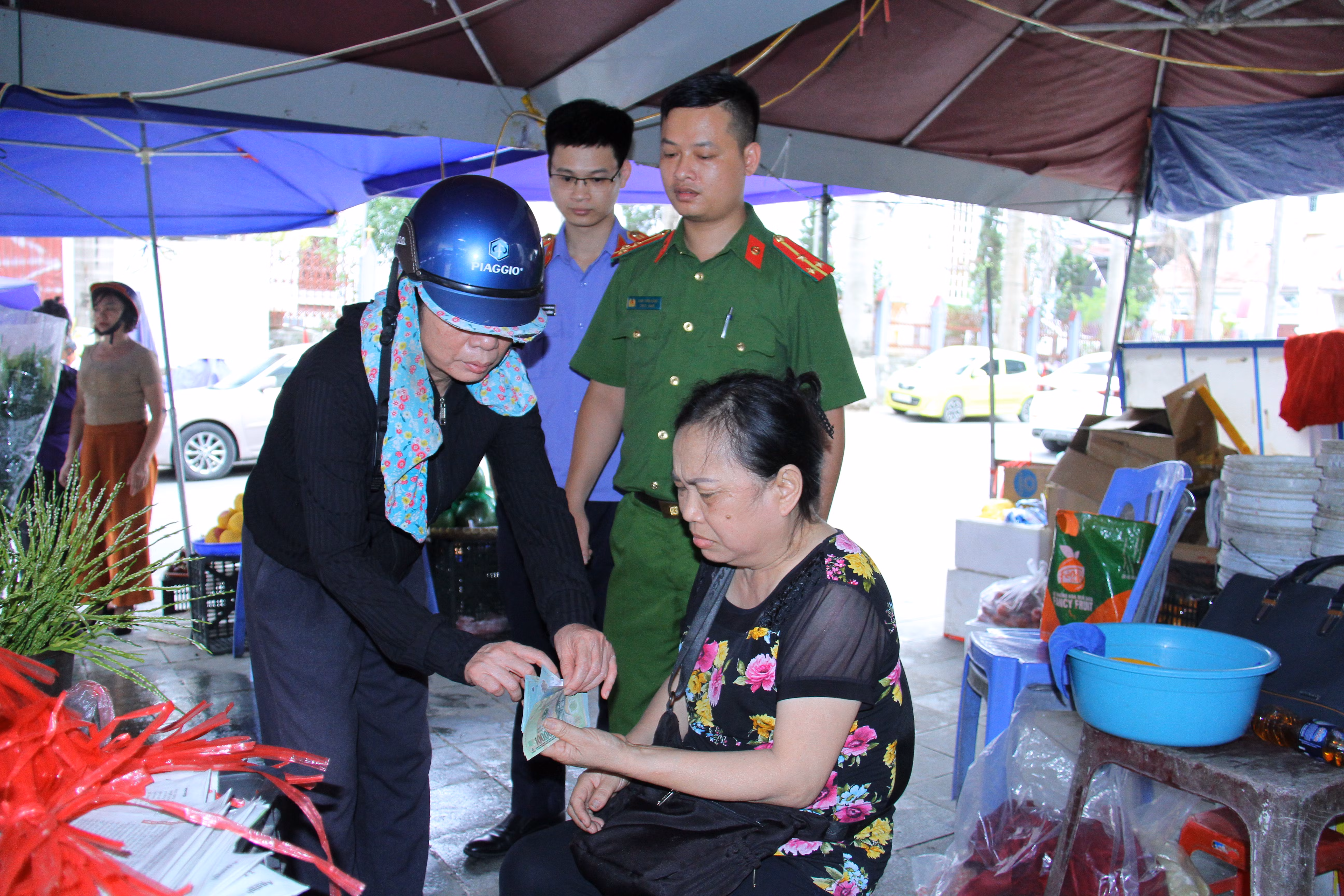 Ảnh 1. Thực nghiệm hiện trường đối tượng Trần Thị Gái áo đen dùng thủ thuật đổi tiền để chiếm đoạt tài sản ở 3 chợ trên địa bàn (3).JPG