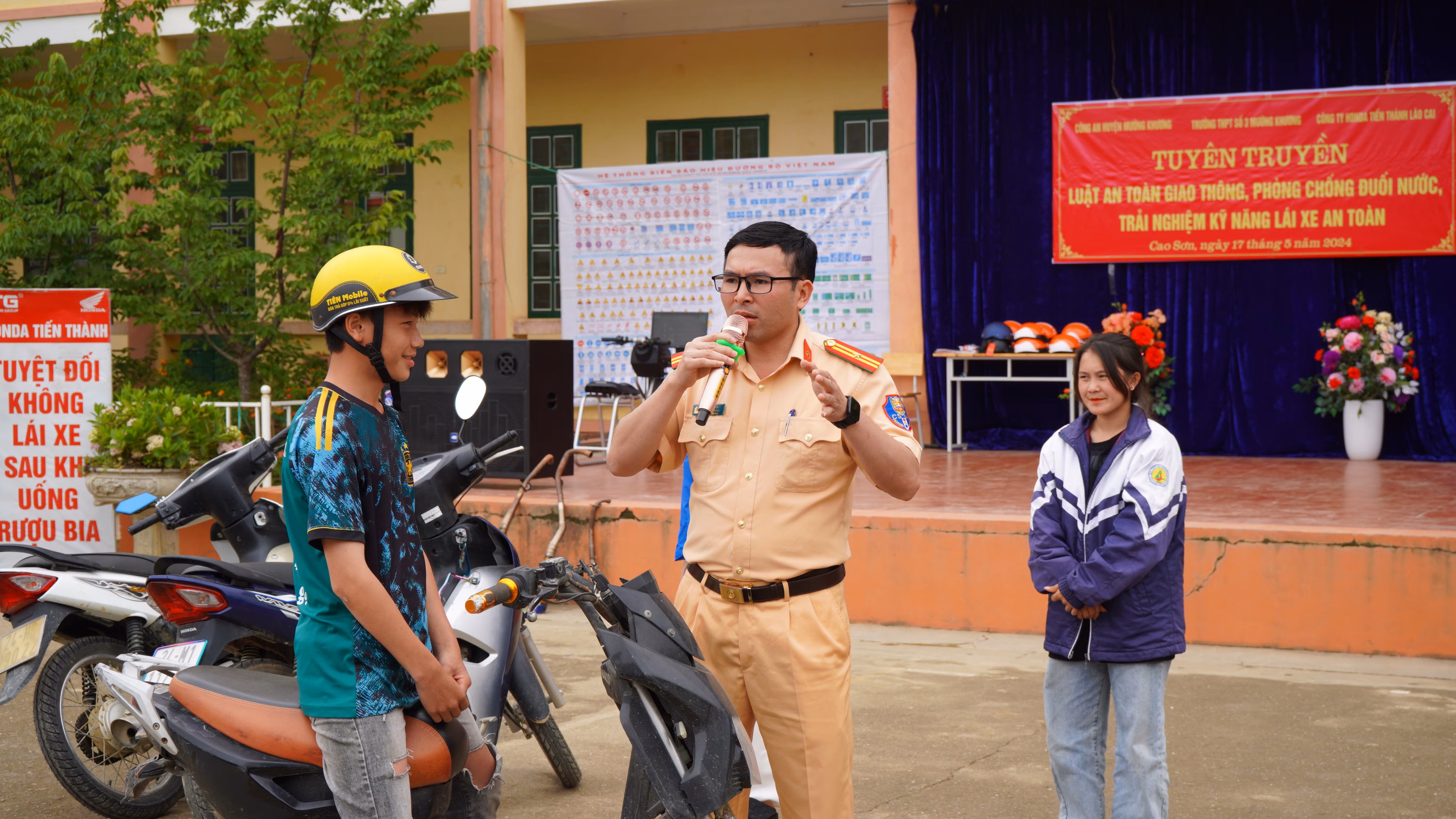 Cán bộ Đội Cảnh sát Giao thông - Trật tự Công an huyện Mường Khương tuyên truyền quy định đối với người ngồi trên xe máy, xe máy điện, xe đạp điện với học sinh .JPG