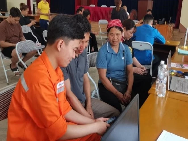 Công nhân điện lực hướng dẫn khách hàng trải nghiệm các dịch vụ tiện ích trên App EVNNPC CSKH..jpg
