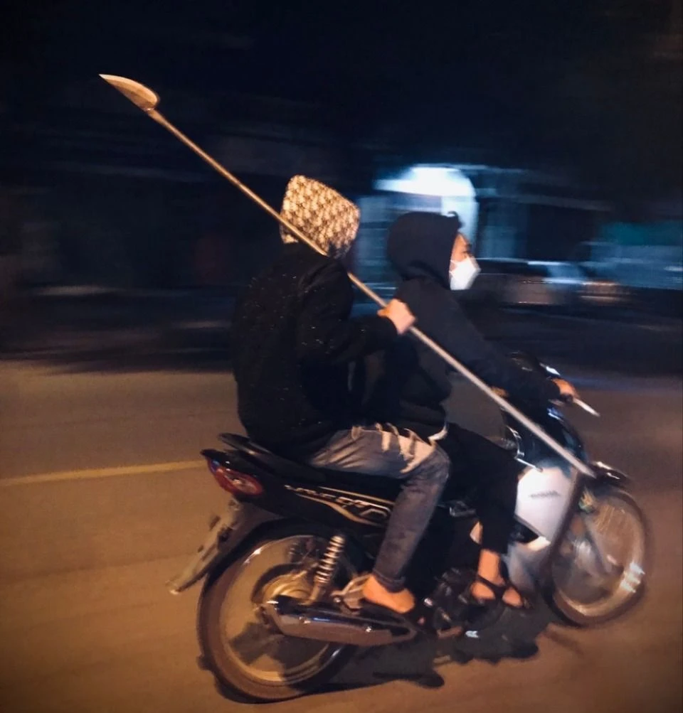 Ảnh 2. Triệu Nhất Quyết cầm tự chế trên xe gắn máy .jpg