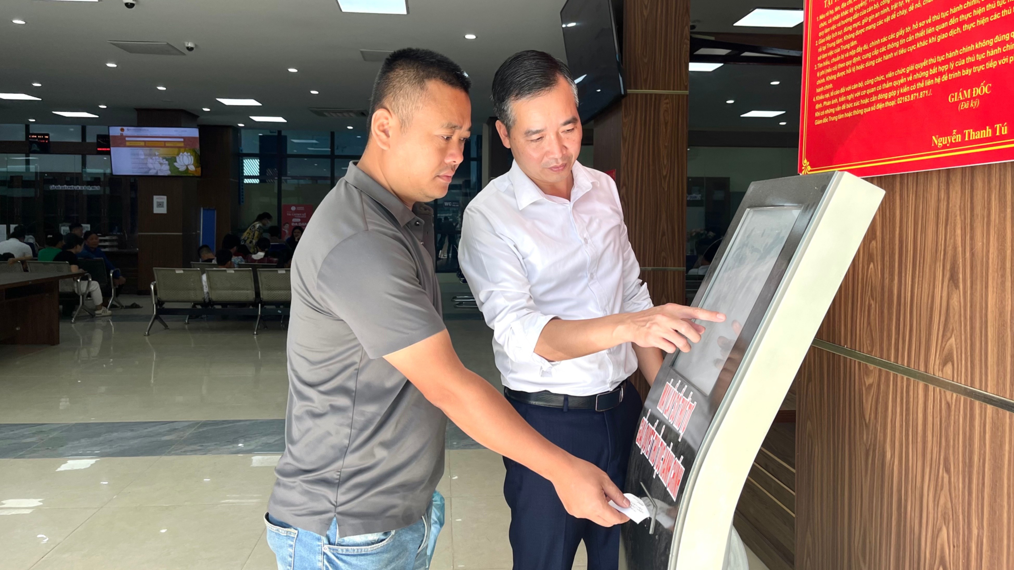 Người dân được cán bộ Trung tâm Phục vụ hành chính công tỉnh Lào Cai hướng dẫn lấy số thứ tự. tempimagesoovtd-2885.jpg