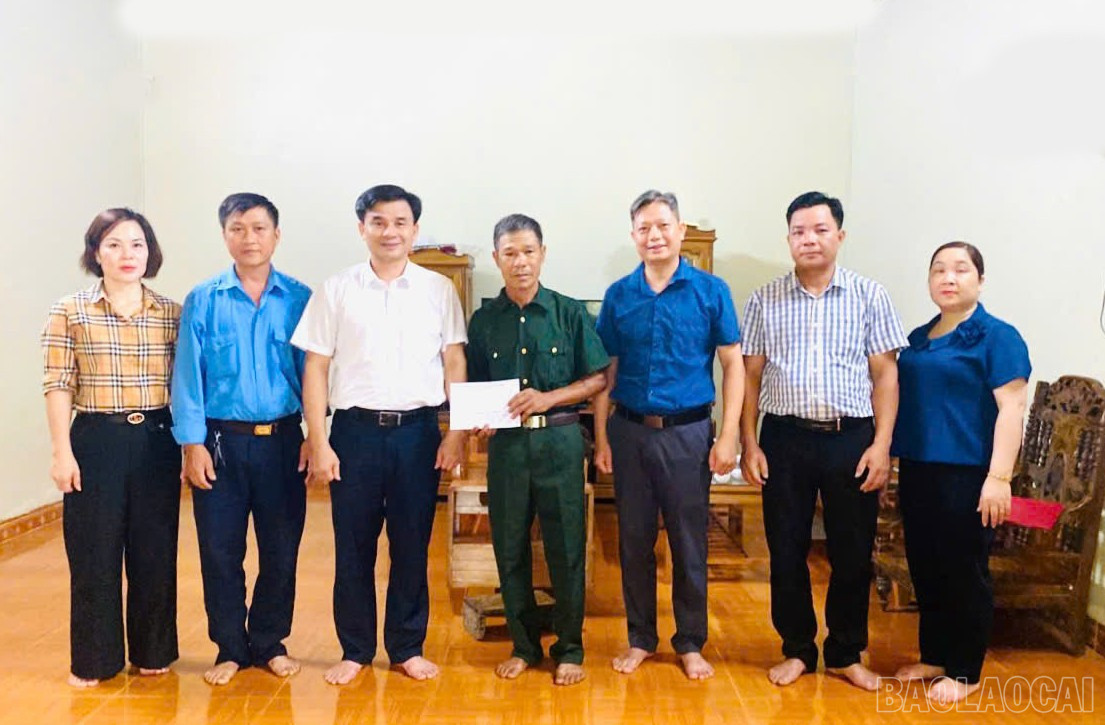Bí thư Đảng ủy, Chủ tịch HĐND xã Đoàn Ngọc Tuyến tặng quà nạn nhân nhiễm chất độc da cam trên địa bàn. baolaocai-br_aef1be60859a33c46a8b.jpg