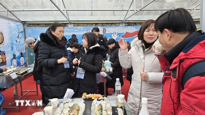 Du khách thưởng thức các món ăn từ cá hồi câu được tại lễ hội.