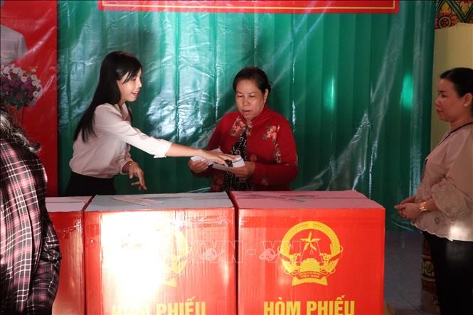 Thành viên tổ bầu cử nhiệt tình hỗ trợ, hướng dẫn cử tri các bước bỏ phiếu đúng quy định. Ảnh: Trung Kiên/TTXVN