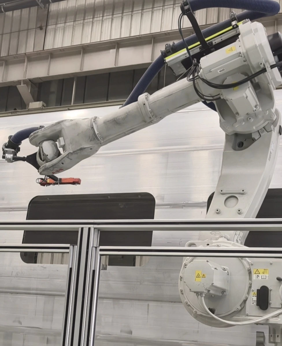 Một cánh tay robot thông minh đang đo kích thước thân tàu trên dây chuyền sản xuất tàu điện cao tốc tại công ty CRRC Tangshan tại Trung Quốc. Ảnh: Global Times