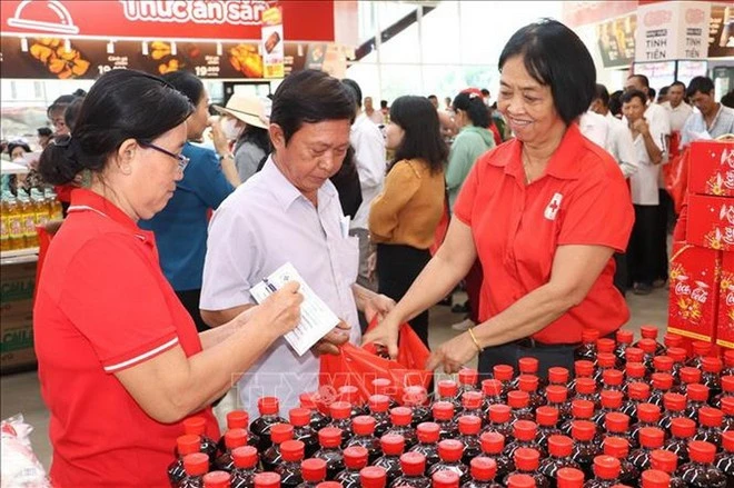 Người dân nhận hàng thiết yếu tại Phiên chợ Phiên chợ Nhân đạo 2025 hướng về người nghèo tỉnh Tiền Giang. (Ảnh: Minh Trí/TTXVN)