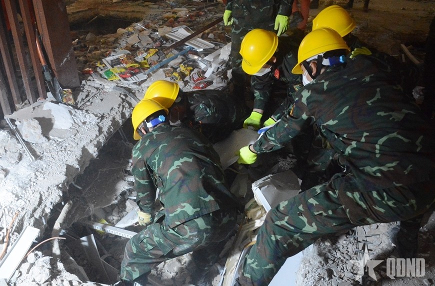 Lực lượng cứu hộ của Quân đội nhân dân Việt Nam tìm kiếm nạn nhân tại khu vực căng tin của Bệnh viện Ottara Thiri, Thủ đô Naypyidaw của Myanmar vào đầu tháng 4-2025. Ảnh: qdnd.vn