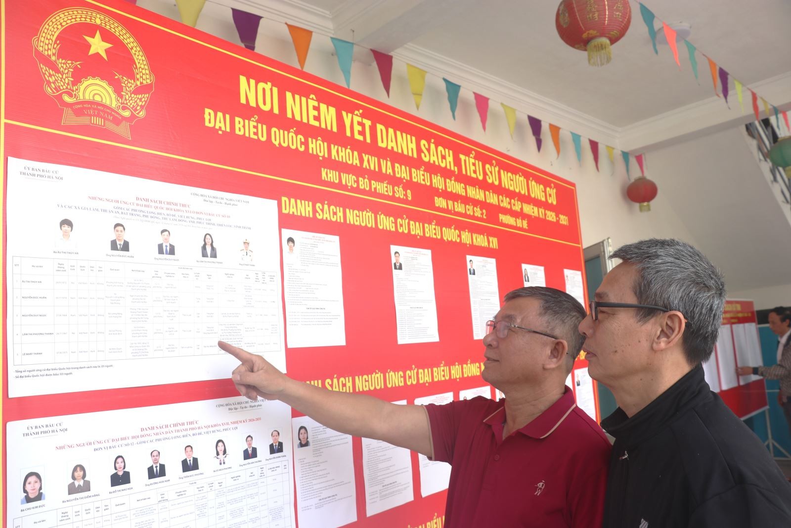 Ông Bùi Văn Hưng (áo đỏ), Bí thư Chi bộ Tổ dân phố 23, Tổ trưởng Tổ bầu cử số 9 và đồng chí Tổ trưởng Tổ dân phố 23, phường Bồ Đề (Hà Nội) kiểm tra khu vực niêm yết danh sách cử tri và tiểu sử tóm tắt người ứng cử đại biểu Quốc hội khóa XVI.