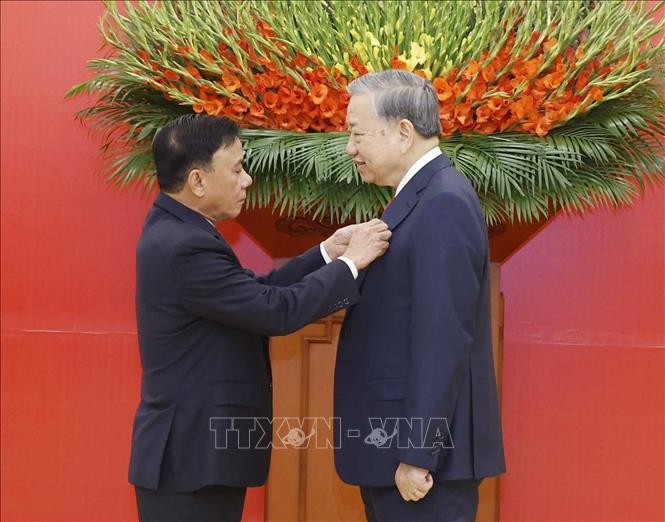 Đồng chí Trần Cẩm Tú, Ủy viên Bộ Chính trị, Thường trực Ban Bí thư trao Huy hiệu Đảng tặng Tổng Bí thư Tô Lâm.