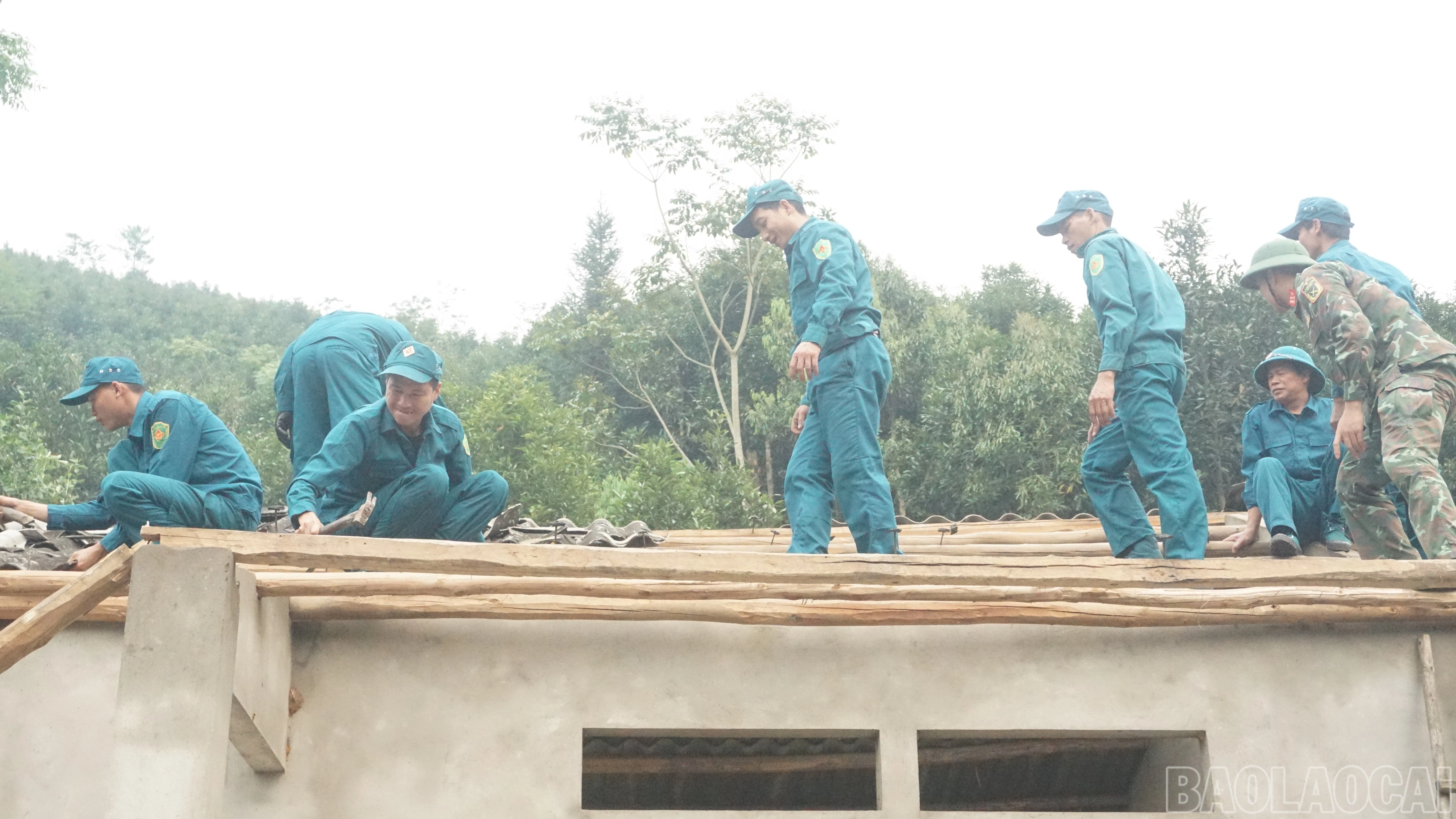 Các lực lượng giúp người dân lợp lại mái nhà.