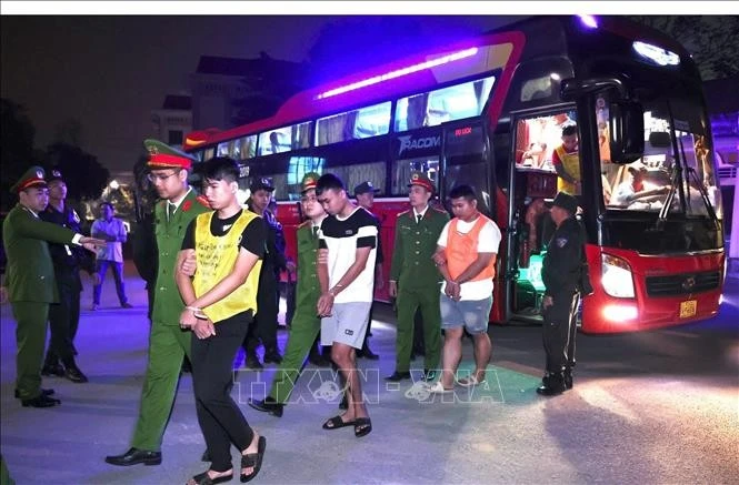 Cán bộ Công an tỉnh Tuyên Quang dẫn giải các đối tượng trong đường dây lừa đảo xuyên quốc gia từ Campuchia về phục vụ điều tra.