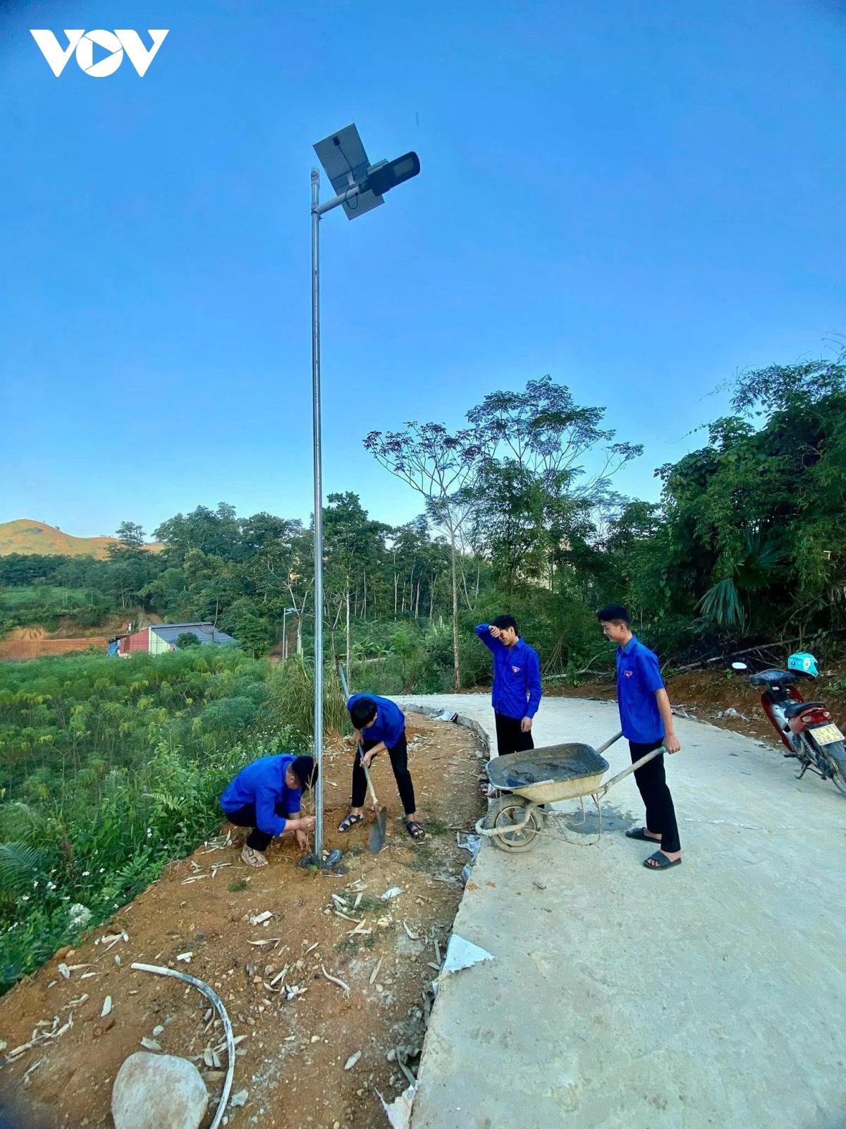 Đoàn viên thanh niên xã Khánh Yên hỗ trợ nhân dân hoàn thành công trình thắp sáng đường quê.