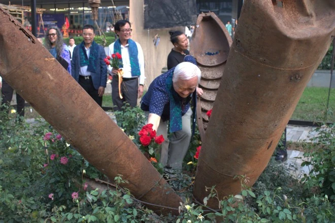 Các đại biểu đặt hoa vào giữa vỏ bom, tượng trưng cho sự sinh sôi nảy nở từ quá khứ đau thương.