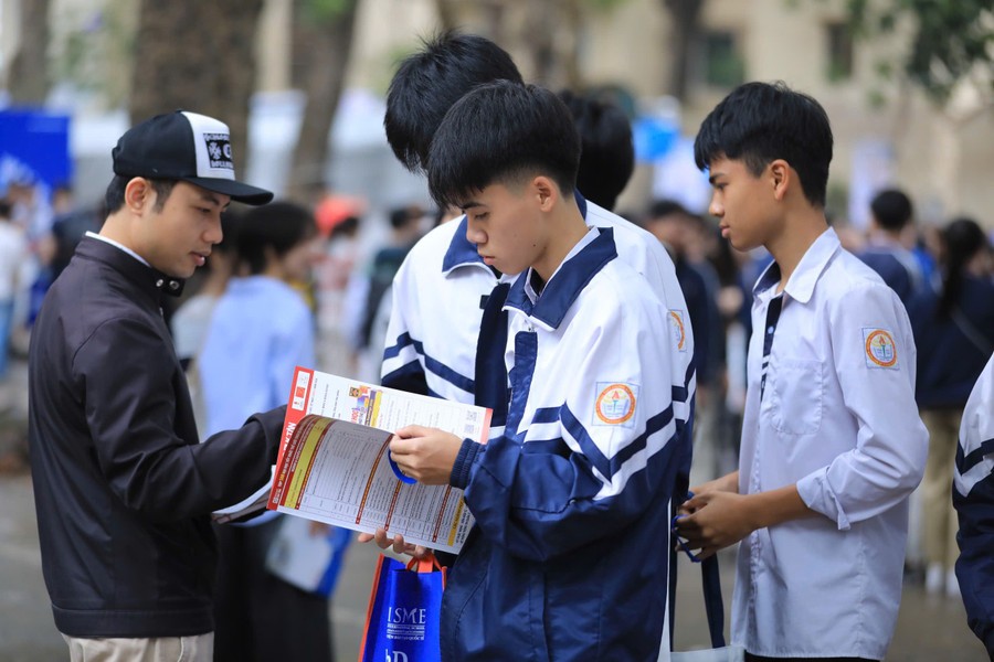 Thí sinh tìm hiểu thông tin tuyển sinh từ tờ rơi của các trường đại học.