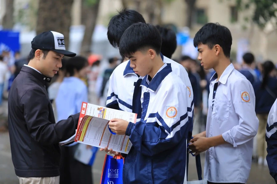 Thí sinh tìm hiểu thông tin tuyển sinh từ tờ rơi của các trường đại học.