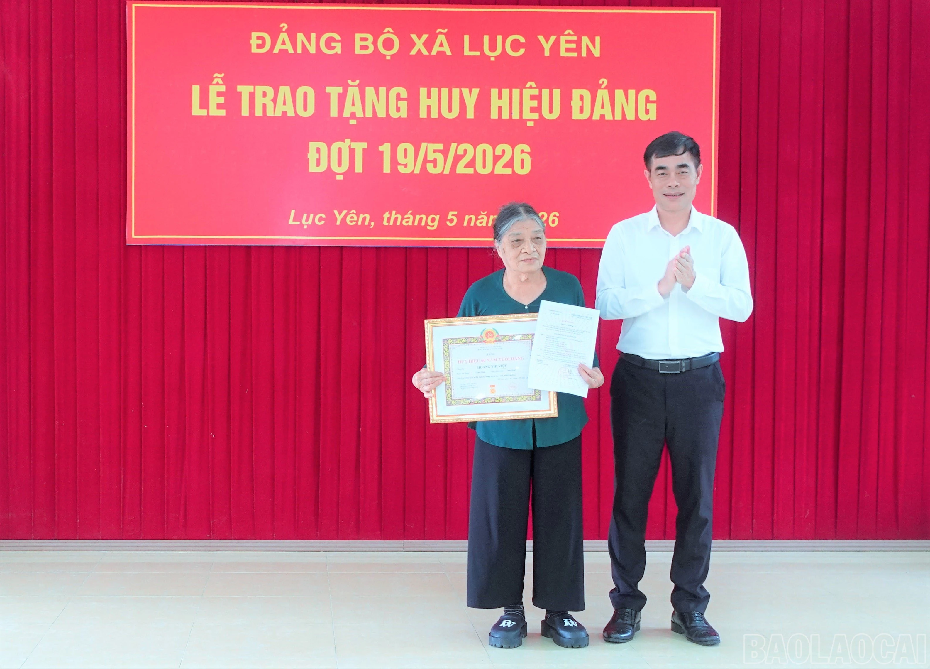 Đồng chí Đỗ Quang Minh - Phó Trưởng Ban Tổ chức Tỉnh ủy trao Huy hiệu 60 năm tuổi Đảng cho đảng viên Hoàng Thị Việt.
