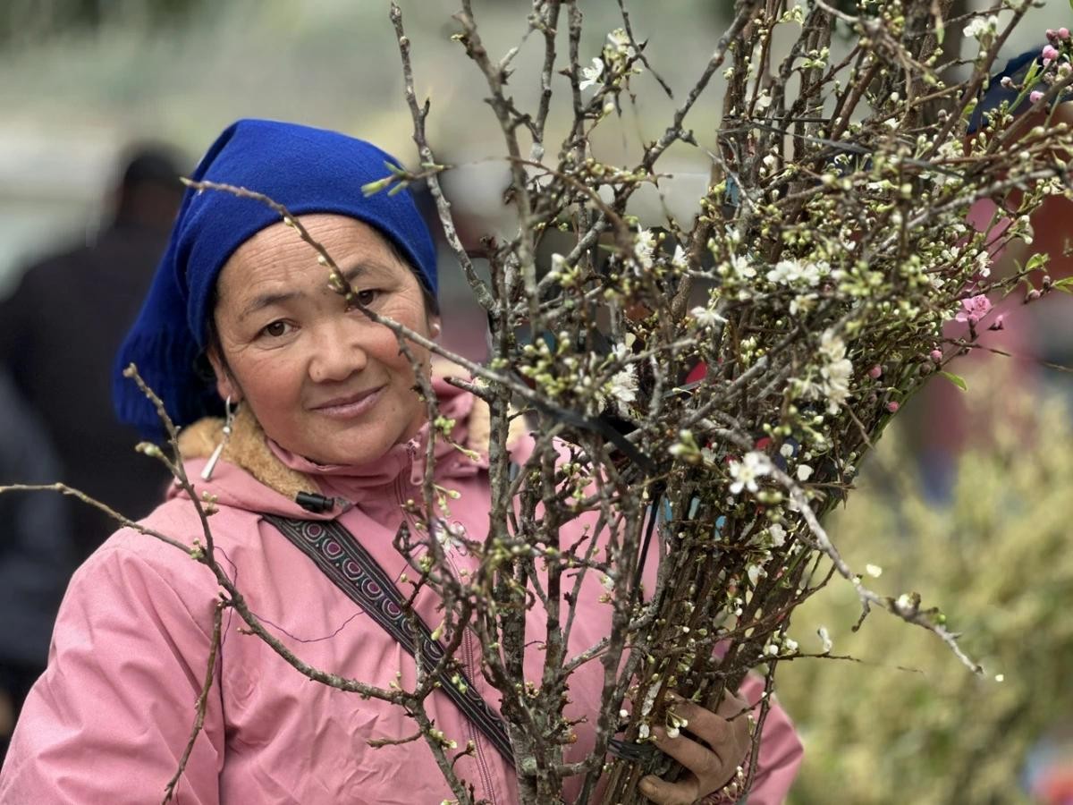 Người bán hoa giữa phiên chợ đông vui.