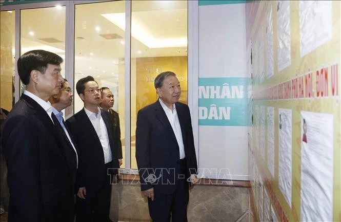 Tổng Bí thư Tô Lâm và các đại biểu tại nơi niêm yết danh sách trích ngang và tiểu sử tóm tắt ứng cử viên đại biểu Quốc hội khóa XVI tại trụ sở UBND phường Hoàn Kiếm, Hà Nội.