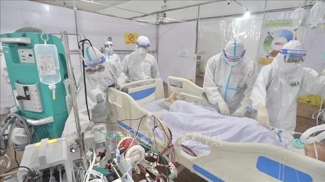 Hình ảnh các “chiến sĩ áo trắng” xả thân trong đại dịch COVID-19 để lại ấn tượng đẹp hơn bao giờ hết trong lòng nhân dân, thầm lặng vì sự an toàn của cộng đồng, cống hiến hết mình để viết nên bản hùng ca tự hào của ngành Y tế. Trong ảnh: Bác sỹ chăm sóc, điều trị bệnh nhân COVID-19 đa tầng tại Bệnh viện dã chiến Tân Bình (TP Hồ Chí Minh).