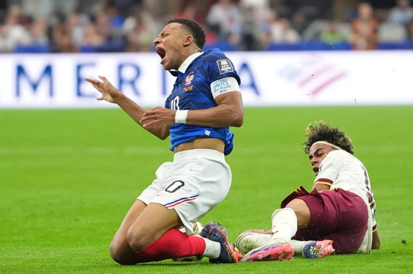 Lamine Yamal (phải) vào bóng từ phía sau Kylian Mbappe (10) trong trận Tây Ban Nha thắng Pháp 2-0 ở bán kết World Cup trên sân AT&amp;T, Arlington, bang Texas, Mỹ ngày 15/7/2026. Ảnh: AP