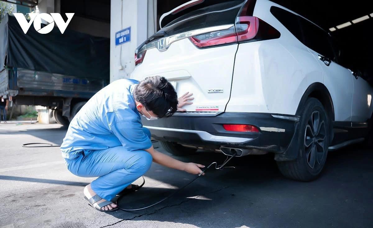 Nhân viên đăng kiểm thực hiện thao tác trong quy trình kiểm định khí thải.