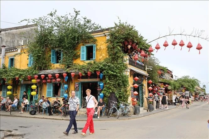 Du khách quốc tế tản bộ trên đường phố Hội An.