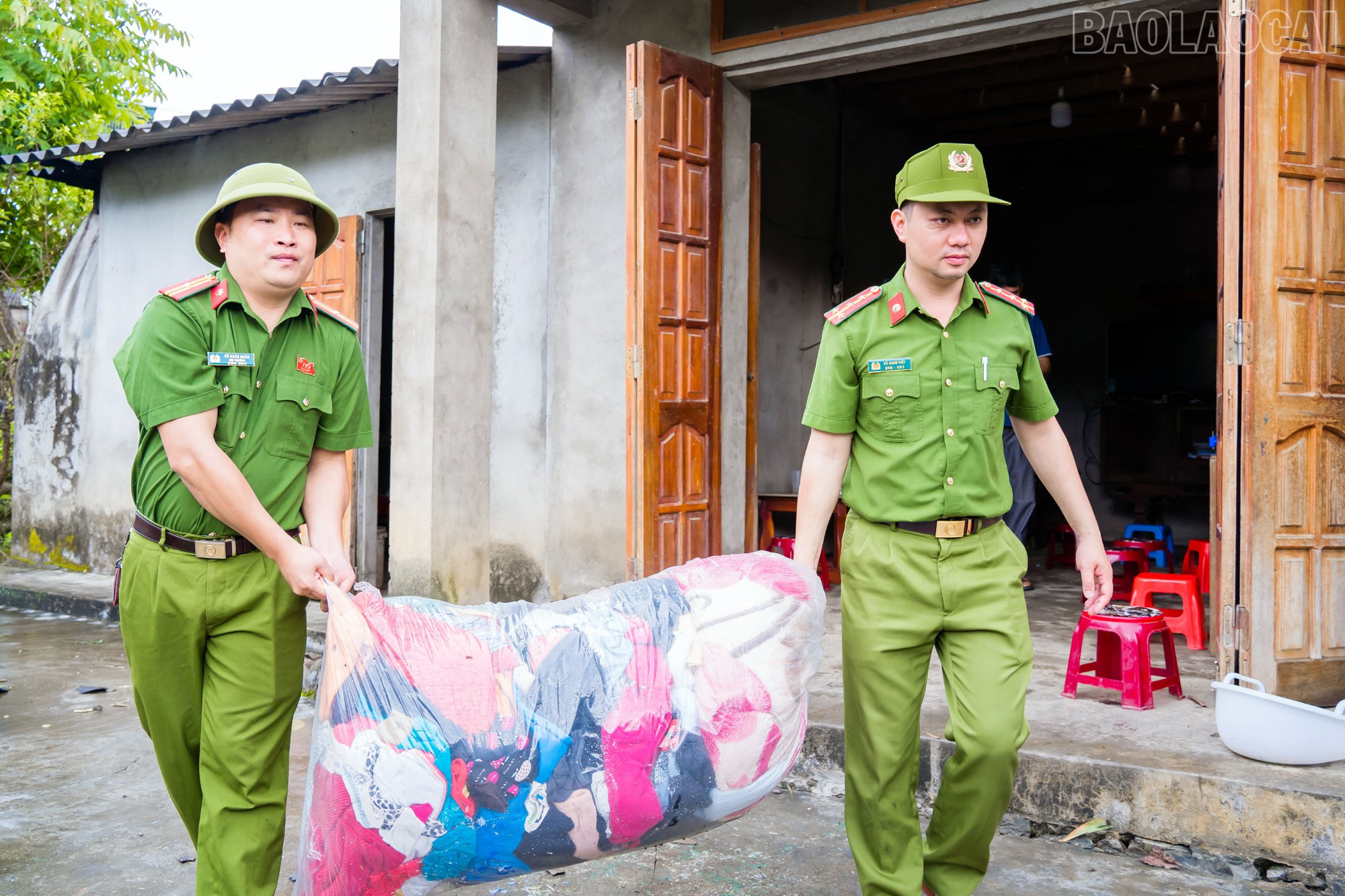 Lực lượng Công an xã giúp người dân vận chuyển tài sản đến nơi an toàn. Ảnh: Hán Hiền baolaocai-tr_mk3.jpg